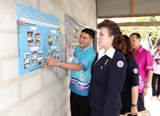 Red Cross President Bussarawadee Ekachai is shown plans to refurbish or build houses for poor people in Banbung and Panthong districts.